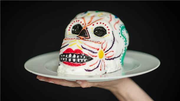 Ein bunter Totenschädelkuchen auf einem Teller.