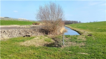 Dieser abgeschottete Graben zwischen den Deponiekörpern Nord (links) und Süd (rechts) nimmt das Betriebsflächenwasser auf. Vor seiner Entwässerung wird das Wasser beprobt und analysiert.
