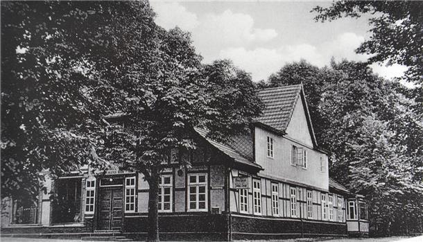 1000 Jahre Sittensen: Architektonische Perlen vergangener Tage Dieses Foto aus dem Bestand von Helga Hink nimmt den Betrachter mit in die Zeit, als die Scheeßeler Straße in Sittensen von Bäumen gesäumt war. Es zeigt die ortsbildprägende Fassade des ehemaligen Gasthauses Kaiser, die bis heute nahezu unverändert blieb.