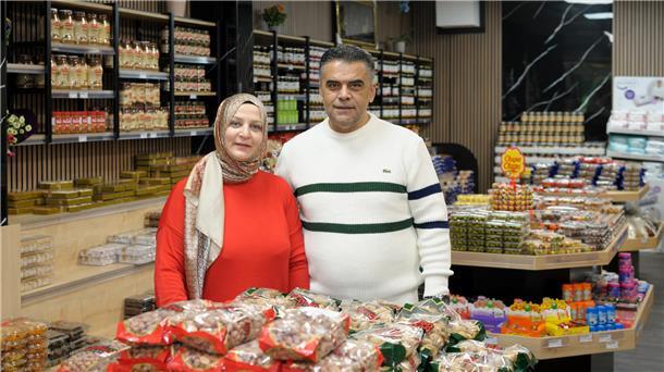 eine Frau und ein Mann in einem Geschäft in dem Nüsse, Süßigkeiten und Marmeladen verkauft werden