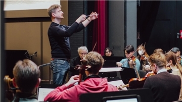 Dirigent Adrian Rusnak und das von ihm gegründete Projekt-Orchester Delmenhorst aus internationalen Musikstudenten 