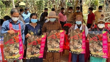 Dorfbewohner in der östlichen Provinz Prey Veng mit Plakaten, die auf die Bedrohung durch das Vogelgrippen-Virus aufmerksam machen.
