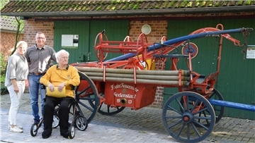 Dorfvereins-Vorsitzende Alexandra Martens (von links) und Bürgermeister Harald Hauschild freuen sich über die Übergabe der Feuerwehrspritze von 1912, die Willi Tödter vor fast 50 Jahren hat restaurieren lassen.