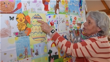 Doris Kröger leitet das Osterpostamt in Ostereistedt und zeigt auf eine Stellwand mit besonderen Bildern von Kindern für Hanni Hase.