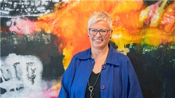 Eine Frau steht vor einem großformatigen Bild