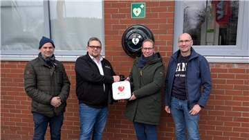 Dr. Christian Janz (links) vom Windpark-Förderverein und Unternehmer Holger Meyer (rechts) freuen sich, dass Thomas Bloch kürzlich den neuen Defibrillator an Carina Neumann vom DRK-Ortsverein überreichen konnte. Holger Meyer und der Windpark-Förderverein haben das Gerät finanziert.