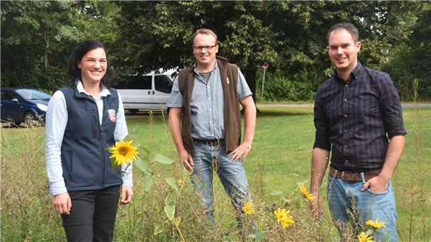 Vertreter des Landvolk-Kreisverbandes stehen auf einem Feld. 