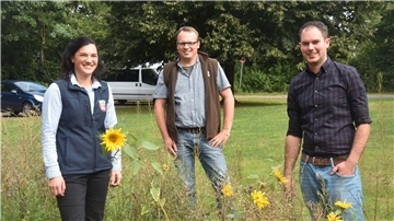 Vertreter des Landvolk-Kreisverbandes stehen auf einem Feld. 