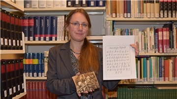 Dr. Julia Kahleyß zeigt Interessierten, wie sich alte Schriften entziffern lassen.