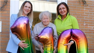 Drei „110-Luftballons“ werden Jubilarin Ingeborg Fründt von OsteMed-Einrichtungsleiterin Melina Kies (links) und der Zevener Tagespflege-Leiterin Monika Lippold (rechts) überreicht.