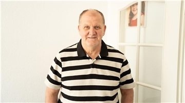 älterer Mann in gestreiftem Polo-Shirt
