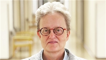 Eine Frau mit Brille blickt in die Kamera.