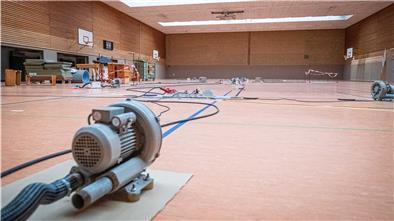 Durch den Grundwassereintritt muss seit rund drei Wochen der Boden der großen Sporthalle des OSC mit Elektrolüftern getrocknet werden. Foto: Hartmann
