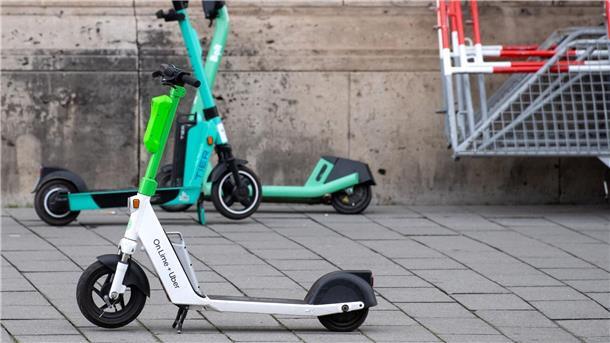 E-Scooter von Lime, Tier und Bolt stehen in Berlin auf einem Gehweg.
