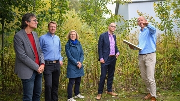 Menschen stehen bei Ecocool am Regenrückhaltebecken.
