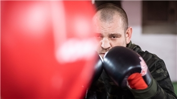 Ein Boxer steht vor einem Boxsack.