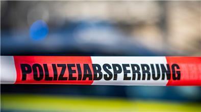 Ein Absperrband der Polizei ist vor einem Streifenwagen aufgespannt.
