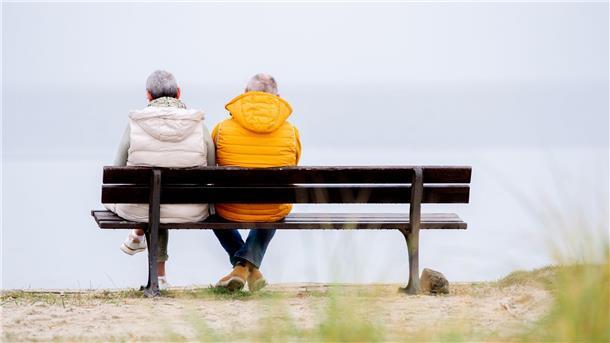 Ein älteres Pärchen schaut im niedersächsischen Harlesiel aufs Meer.