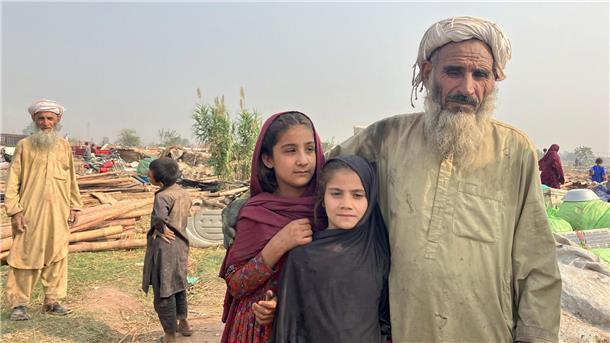 Ein afghanischer Vater und seine Töchter stehen zwischen den Überresten eines Flüchtlingslagers am Stadtrand von Islamabad, das von Bulldozern abgerissen wurde.