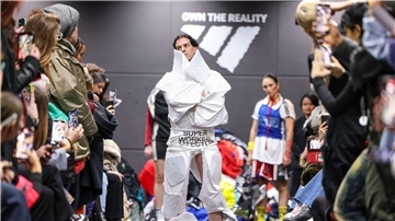 Ein Aktivist bei einer als Adidas-Show getarnten Performance auf dem Catwalk.