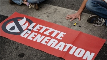 Ein Aktivist der Gruppe Letzte Generation hat sich auf eine Straße festgeklebt und blockiert eine Kreuzung. (Symbolbild)