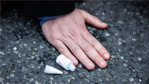 Ein Aktivist der Klimaschutz-Initiative „Letzte Generation“ ist mit der Hand auf die Straße geklebt.
