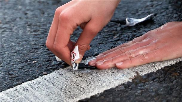 „Letzte Generation“ kündigt Unterbrechung der Proteste an Ein Aktivist von „Letzte Generation“ klebt seine Hand mit Sekundenkleber auf der Straße in Berlin während einer Sitzblockade fest.