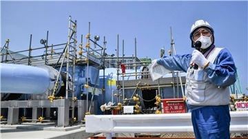 Ein Angestellter erklärt die Anlage, mit der aufbereitetes radioaktives Wasser aus dem Kernkraftwerk Fukushima ins Meer geleitet werden soll.