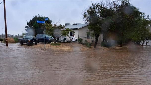 Sturm „Hilary“ zieht über Kalifornien hinweg Ein Anwohner prüft während eines Regengusses in Palmdale die Überschwemmungen rund um sein Haus.