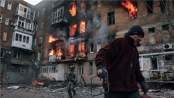 Krieg gegen die Ukraine: So ist die Lage Ein Anwohner verlässt in Bachmut sein Wohnhaus, das nach einem Beschuss in Flammen steht.