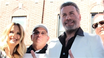 Ein Anzug, der von US-Hollywood-Star John Travolta (r) im Kultfilm „Saturday Night Fever“ getragen wurde, wurde für rund 235.000 Euro versteigert.