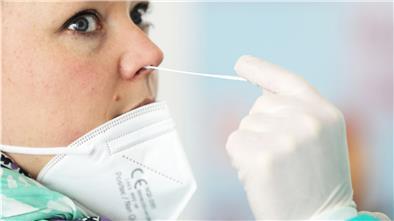 Ein Apotheker nimmt in einem Nebenraum bei einer Frau einen Abstrich in der Nase vor. Bis es überall (kostenlos) so weit ist, sind noch viele Fragen zu klären.