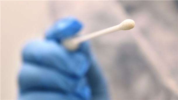 Corona-Infektionsgeschehen weiter leicht rückläufig Ein Arzt hält einen Tupfer, mit dem ein Abstrich für einen Coronatest gemacht wird.