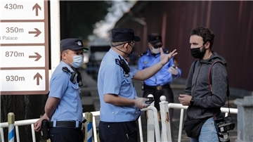 Ein ausländischer Journalist wird in Peking von Polizisten angehalten und befragt, nachdem er versucht hatte, die Busse von Delegierten des chinesischen Volkskongresses zu fotografieren (Archivbild).