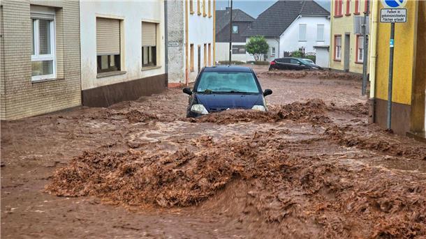 Hochwasser im Südwesten - Aufräumen und abwarten Ein Auto bahnt sich den Weg durch die Wassermassen in Kirn.