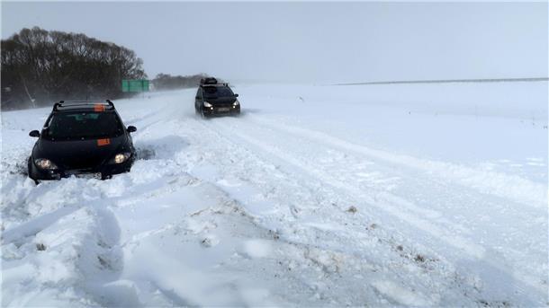 Ein Auto ist auf der Straße zum Flughafen in Pograd in der Slowakei im Schnee stecken geblieben.