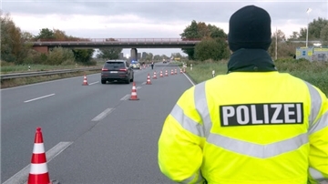 Ein Auto wird von der Polizei auf die Kontrollstelle geleitet. 