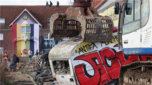 Abrissbagger in Lützerath - Widerstand bröckelt Ein Bagger greift bei der Räumung nach einem Wohnwagen.