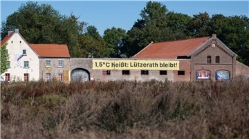 Ein Banner mit der Aufschrift „1,5 Grad heißt: Lützerath bleibt!“ an einem alten Hof in Lützerath. Doch nun soll das Dorf weichen.