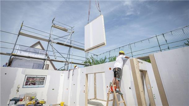 Fertighaushersteller rechnen 2023 mit weniger Umsatz Ein Bauarbeiter arbeitet im Rohbau eines Fertighauses.