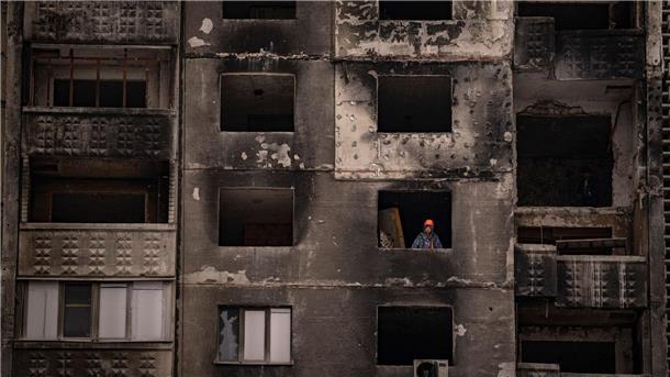 Krieg gegen die Ukraine: So ist die Lage Ein Bauarbeiter steht am Fenster eines durch russischen Beschuss beschädigten Gebäudes in Charkiw.