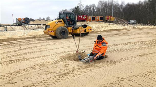Bilderstrecke von der A27-Baustelle: Die besten Fotos der Woche Ein Bauarbeiter untersucht, ob der Sand auf der aufgefüllten Baugrube bereits ausreichend verdichtet.