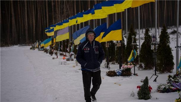 Krieg gegen die Ukraine: So ist die Lage Ein Bestatter geht durch die „Allee der Helden“ auf dem Friedhof von Irpin.