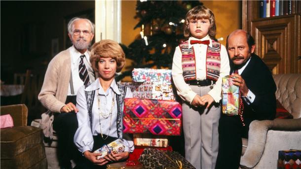 TV-Tipp heute: Weihnachten bei Hoppenstedts - NDR, 15.45 Uhr Eine Familie sitzt gemeinsam vor einem Tannenbaum.