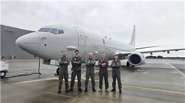Fünf Männer stehen vor einem Flugzeug.