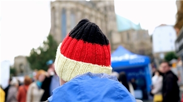 Ein Besucher des Bürgerfestes zum Tag der Deutschen Einheit trägt auf dem Domplatz eine schwarz-rot-goldene Mütze.