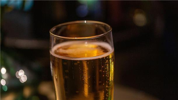 Ein Bierglas steht auf einem Tisch in einer Bar.