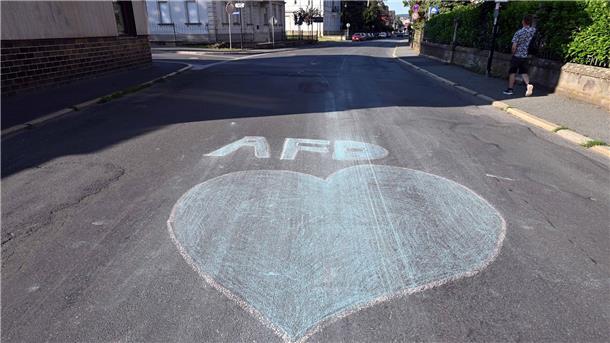 Ein blaues Herz und der Schriftzug AfD sind mit Kreide auf eine Straße in Sonneberg gemalt.