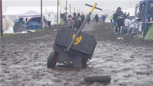 Müll, Matsch und Stau: So läuft die ABREISE beim Deichbrand-Festival (Fotos) Ein Bollerwagen wird im Matsch zurückgelassen.