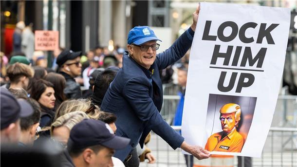 Ex-Präsident vor Gericht - Anklage in 34 Punkten gegen Trump Ein Demonstrant hält ein Plakat vor dem Trump Tower in New York.